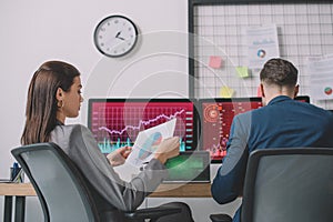 Analysts working with computers and graphs in office