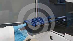 Analytical chemist takes a vials to auto sampler of HPLC system.