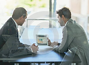 Analyzing the companys numbers. Shot of two colleagues looking at a graph on a digital tablet together in an office.