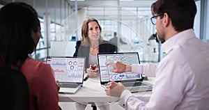 Analyzing data on analytics dashboard during multicultural team meeting