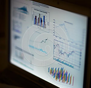 analyzing investment charts with laptop.