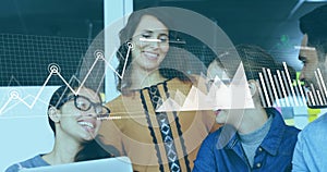 Analyzing office team collaborating on data charts at modern workspace, with laptop and graphs