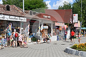 Anapa, Russia, July, 16, 2018. People walking near cafe `Tender coast 1` and small shops with Souvenirs and beach accessories at a