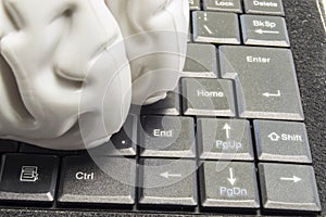 Anatomical model of the human brain lies on a black computer keyboard picture close up. Concept photo of brain games, computer gam