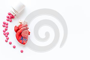 Anatomical plastiline heart with pills. Cardioigy disease treatment