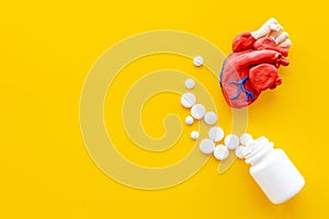 Anatomical plastiline heart with pills. Cardioigy disease treatment
