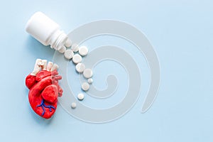 Anatomical plastiline heart with pills. Cardioigy disease treatment