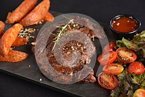 ancho beef steak with rustic roast potatoes and salad with herb dressing photo