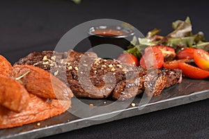 ancho beef steak with rustic roast potatoes and salad with herb dressing photo