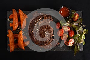 ancho beef steak with rustic roast potatoes and salad with herb dressing photo