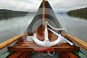 Anchor on boat nose on lake in cloudy weather