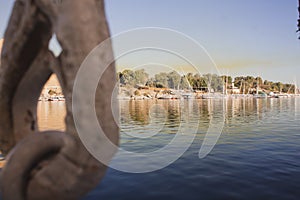 An anchor in detail and boats in the coast of Nile river