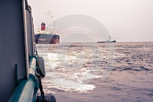 Anchor-handling Tug Supply AHTS vessel at work with FPSO tanker