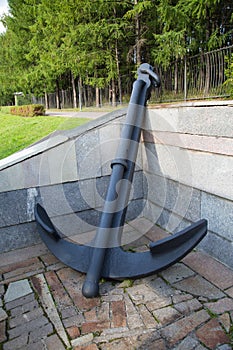 Anchor ocean ship in the Park on a background of green trees.