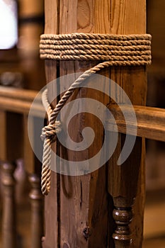 Anchor rope tie up the wooden pillar with copy space. thick rope tied around wooden pillar, close object picture of vintage ship