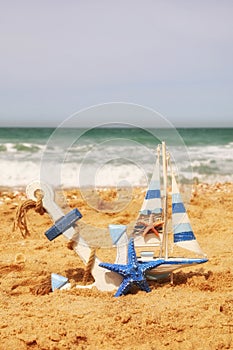 Anchor, sailboat on sea sand and ocean horizon