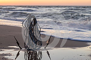 Anchor in the sand by the ocean, seascape at sunrise