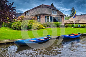 Anchored boats on the water canal in Giethoorn village, Netherlands