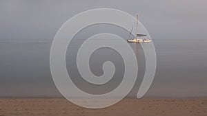 Anchored Caribbean sailboat at dusk on isolated simple background