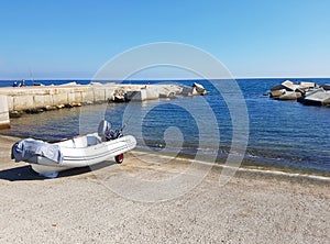 Anchored dinghy near sea with blue sky