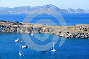 Anchored yachts and boats in blue sea bay