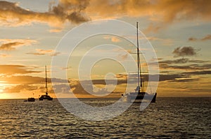 Anchoring ships in tropical bay at sunset. Small yachts and catamarans on sea water during dusk. Santa Lucia.