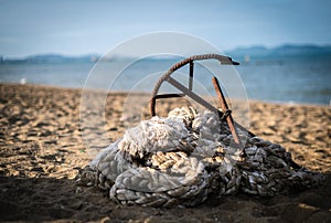 Anchors and piles of rope gather on the beach at the mooring area for traditional fishing boats