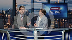 Anchors talking breaking news evening television studio closeup. Hosts speaking