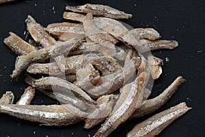 Anchovies fish on black isolated background