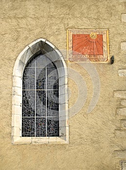 Anciant church window with sun dial photo