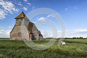 Ancient 13th Century derelict church in vibrant blue sky Summer