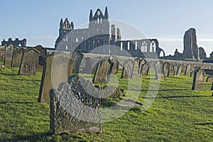 Ancient abbey ruins with gothic architecture and cemetary in rural landscape