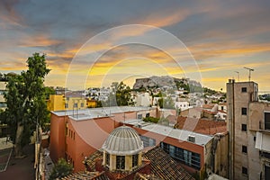 The ancient Acropolis and Parthenon on Acropolis hill viewed from the Plaka region below in the city of Athens, Greece at sunset