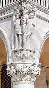 Ancient aged sculpture of beautiful Eva with apple and Adam from Bible story of Creation at Doge Palace in Venice, Italy, closeup