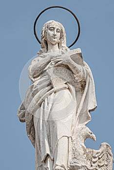 Ancient aged sculpture of beautiful Holy Maria at roof of Santa Maria Assunta Jesuits Church in Venice, Italy, details, closeup photo