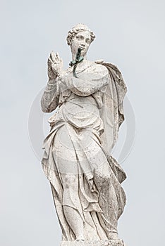 Ancient aged sculpture of beautiful praying Angel with wings at roof of Santa Maria Assunta Jesuits Church in Venice, Italy, photo