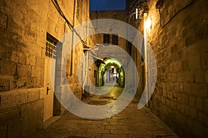 Ancient alley in Jewish Quarter at night time, the old city Jerusalem. Mystical atmosphere of deserted road leading to an old city