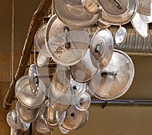 Ancient alluminium cookware hanging from the ceiling