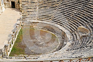 Ancient antique amphitheater in city of Hierapolis in Turkey. Steps and antique statues with columns in the amphitheater