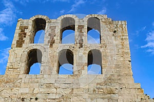 Ancient arches of the Roman theater on the Acropolis in Athens Greece against a beautiful blue sky with whispy clouds