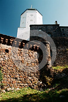 Ancient architecture concept. Tall stone wall, fortress and tower in Vyborg, Russia in sunny summer day