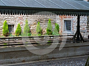 Antique public laundry in the upper city of Bergamo. Italy with green bushes and sunlight background