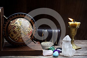 Ancient astrology. Old astrology globe and books with lighting candle