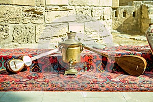 Ancient azerbaijani musical instruments tar and saz with old vintage azeri tea pot for boiling water photo