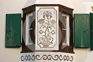 Ancient balcony with wooden windows in Engadine valley Switzerland