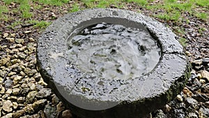 Ancient basin dug by hand in the rock and drops of water