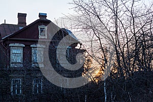 Ancient beautiful mysterious house in the forest at sunset