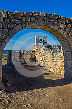 Ancient bell against ruins