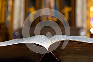 Ancient bible with a soft focus Catholic Christian alter in the background