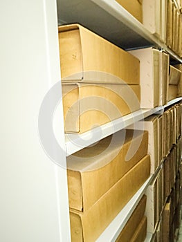 Ancient books in cardboard boxes on shelves in a museum